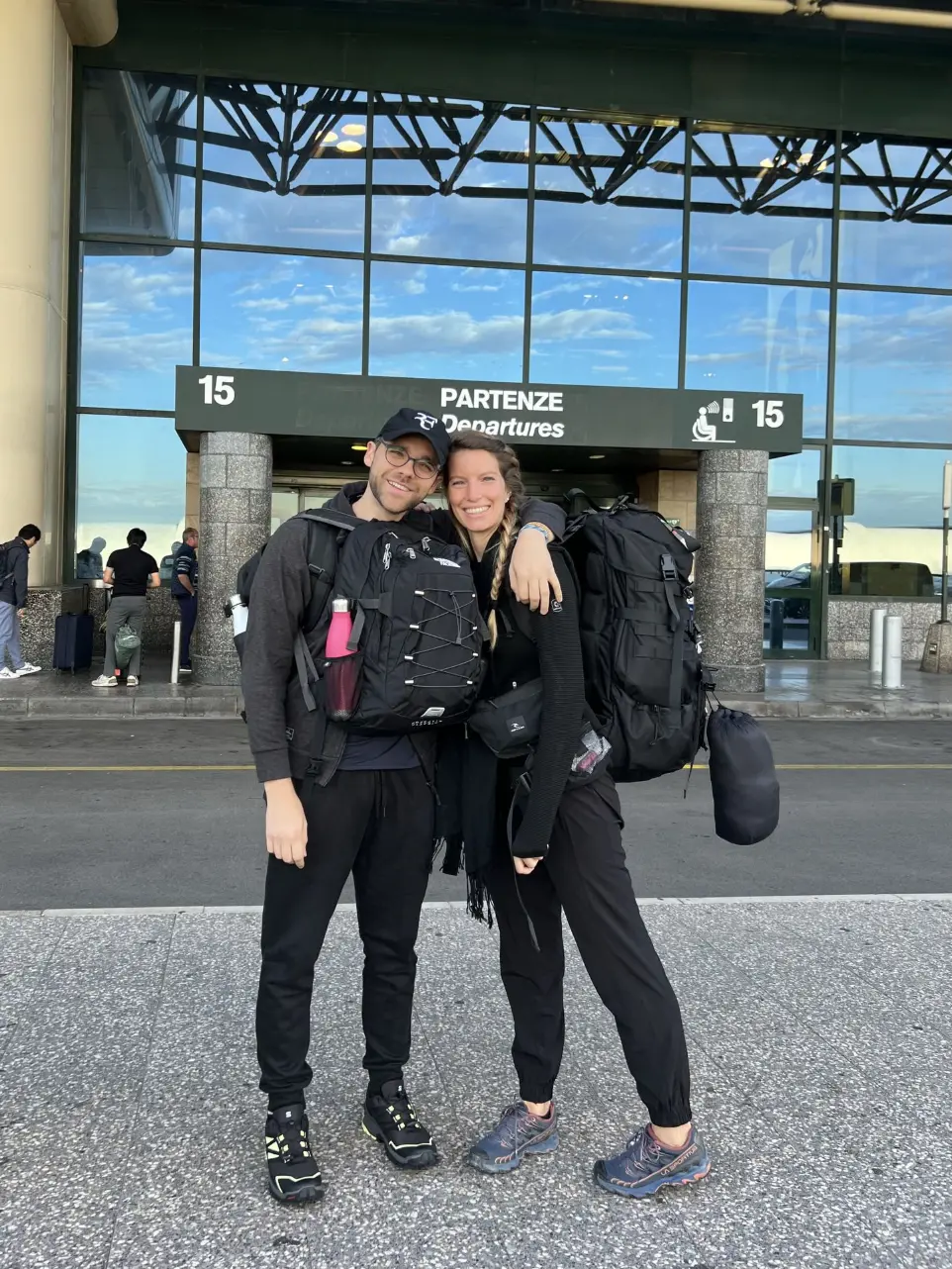 Carola and Martín with their backpacks at the airport, ready for a trip